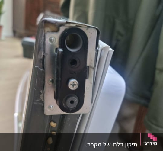 חלק מתכת עם ברגים על דלת מקרר